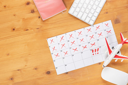 Calendar and reminders for business trip, travel and vacation. planner with airplane model on desktop with keyboard, mouse, coffee and succulent. marking important dates and days in a diary at the office desk. Reminder conceptの写真素材