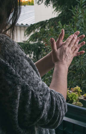 Woman Applauding In His Window In Gratitude To The Health Personnel And Other Groups During The Confinement For The Coronavirusの写真素材