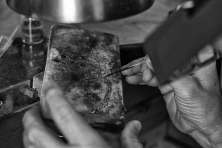 Hands of a craftsman jeweler working on jewelry. Goldsmith. Goldsmith workshop jewels and articles...