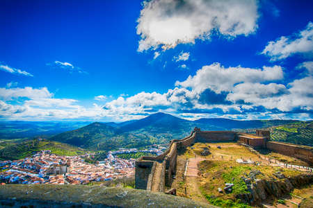 Landscape and castle of the city of Feria located in Extremadura, Spain. Landscape of a town and its castle with a beautiful valley and blue sky surrounded by nature.のeditorial素材