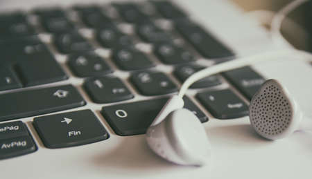 Teleworking concept. Technology. Close-up of headphones and keyboard of a laptop. Telecommuting from home.の写真素材