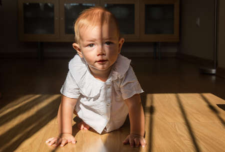A cute little boy crawling around the house Happy baby crawling on the floor towards the camera.の写真素材