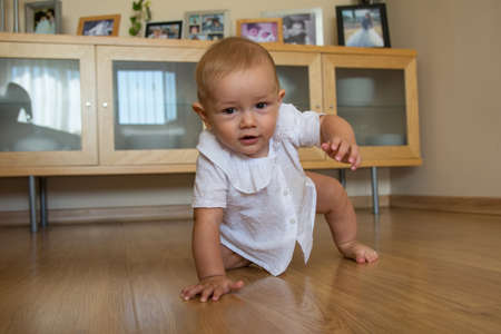 A cute little boy crawling around the house Happy baby crawling on the floor towards the camera.の写真素材