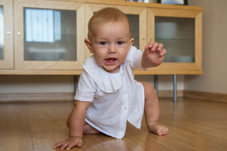 A cute little boy crawling around the house Happy baby crawling on the floor towards the camera.の写真素材