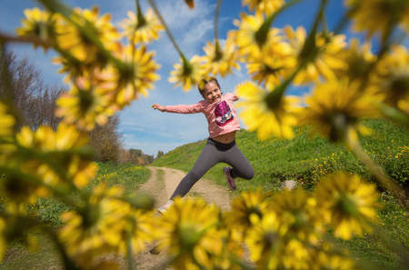 Creative Photography Of A Happy Girl Jumping In The Field Surrounded By Yellow Flowers. Spring...