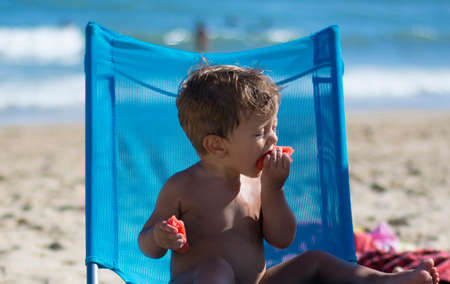Child Eating Watermelon On The Beach. Beautiful Child On The Beach. Summer vacation