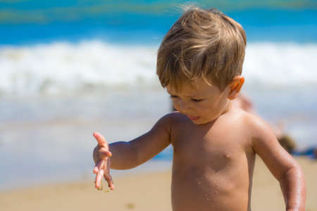 Beautiful Child Smiling On The Beach. Close-up Of A Child On The Beach. Summer Conceptの写真素材