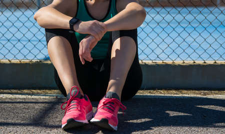Woman Athlete Resting Sitting On The Floor Of A Sports Center. Concept Sports. Copy Space