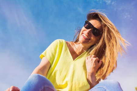 Happy Young Woman At The Beach. She Moves Her Hair. Image Taken From Below. Happiness Concept.の写真素材