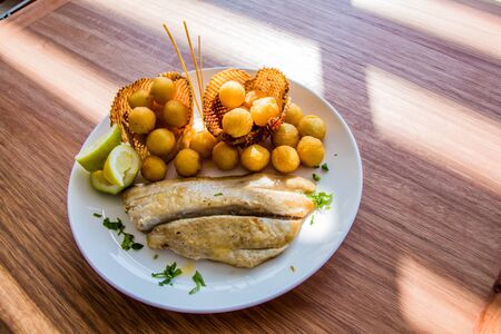 Fish fresh from the ocean and fried potato ballsの写真素材