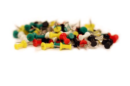 A horizontal colour photograph of multi coloured push pins isolated on a white background.の写真素材