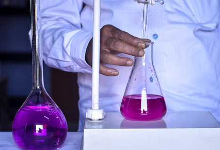 The scientist is conducting an acid-base titration in the lab, measuring precisely the amount of acid or base needed to neutralize a solution. Accurate results are critical in this essential chemical process.の写真素材