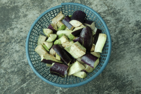Sliced eggplant in a colander on a stone backgroundの写真素材
