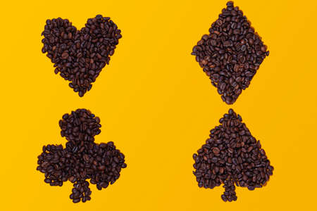 Coffee beans grouped in the shapes of the four poker card symbols: hearts, spades, clubs and...