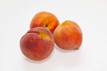 Three ripe peaches clustered in the center isolated on a white background.の写真素材