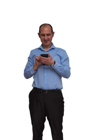 Bald guy dressed in blue shirt and black pants touching touch screen of his smartphone isolated on white background. May be an office worker or banker.の写真素材