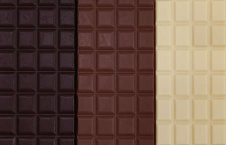 Close-up of three chocolate bars together, one is dark chocolate, one is milk chocolate and one is...