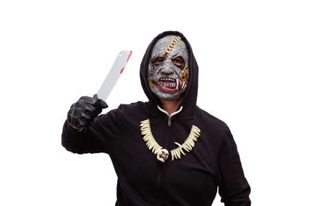 A man disguised in a zombie mask wearing a black hooded sweatshirt and gloves is threatening with a bloody butcher knife.の写真素材