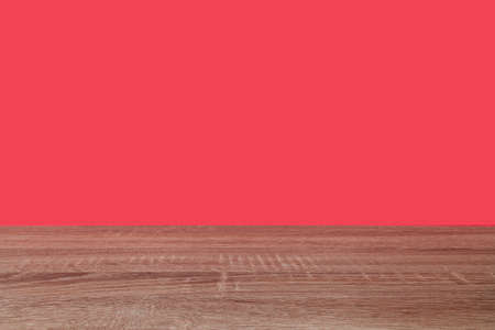 Empty space composed of an oak-colored wooden surface and a red background. There is a lot of copy space.の写真素材
