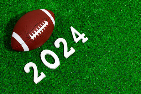 American football ball next to 2024 number whose figures are made of white painted wood isolated...