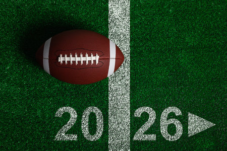 Football is on the field with the number 2026 written on the ground. The football is on the grass...