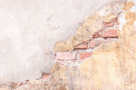 Old vintage red brick wall half beige painted and cracked. Abstract pattern for background.