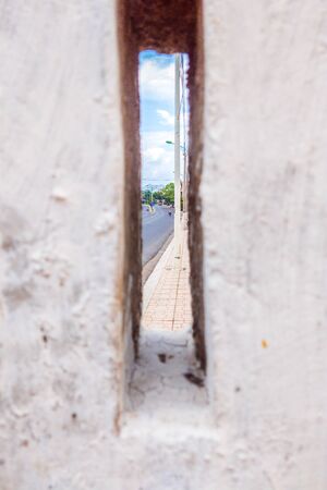 A Hole in a concrete wall with city view.の写真素材