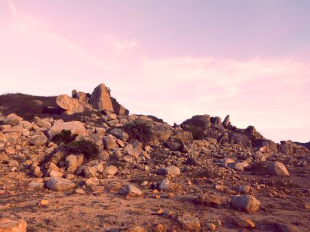 Beautiful dramatic dark blue pink sunset sky with clouds over the rock stone mountainsの写真素材