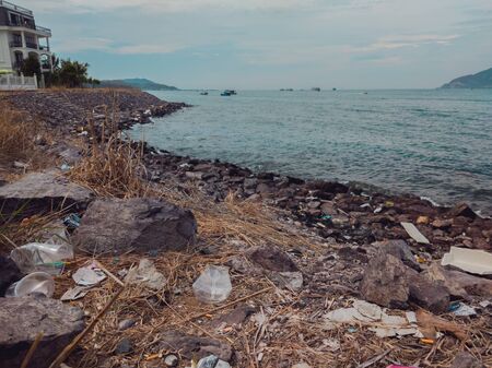 Environmental disaster, ecological pollution, garbage scattered on the ground waste near sea. Problem of contamination of the environment. Planet ecology. Unauthorized dump of garbage outdoorsの写真素材