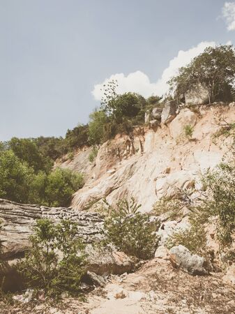 Natural background. Closeup edged shabby cliff cracks. Gray-brown stone rock texture of mountains. Vintage and faded matt style colour in tinted photo. Concept of geolog, mountaineering or hard work.の写真素材