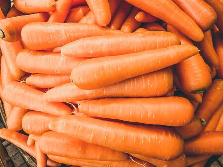 Close-up heap of carrot. Harvested young fresh organic bio raw vegetable on the market. Cooking, homemade gardening and healthy food concept, vitamins for strong immunityの写真素材