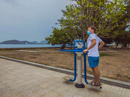 Man doing physical exercises, push ups, strength exercises, leans in empty outdoor public city park...