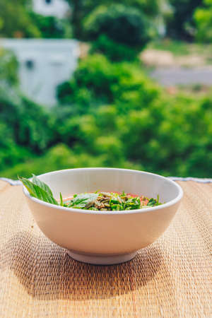 Delicious beautiful raw vegan salad from green leaves mix vegetables in white plate. Cooking recipe Blended tomato carrot cauliflower, cut parsley cilantro dill greenery cucumber, basil pumpkin seedsの写真素材