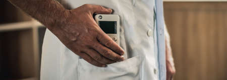Young man hands hold bio rezonans therapy alternative medicine device, small portable life balance...