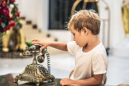 Boy take telephone receiver, play with antique vintage rotary old landline hang up phone beautifully...