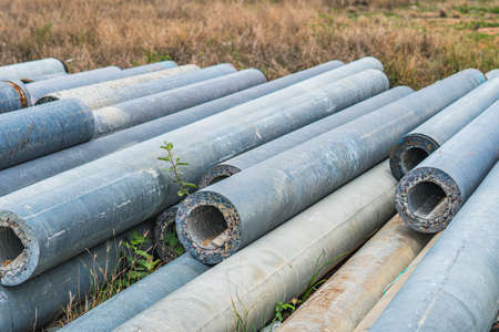 Stack of concrete pipes at a construction site outdoors warehouse. Civil infrastructure, industry...