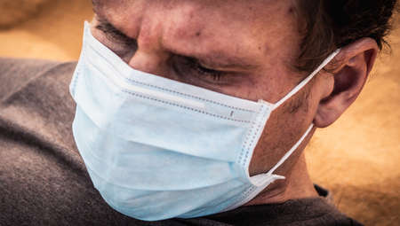 Close-up side portrait man wear protect mask, face expression emotion, furrowed brow wrinkle, look...