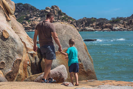 Back Dad care Son near sea, walk spend time together explore new. Concept father day family union...