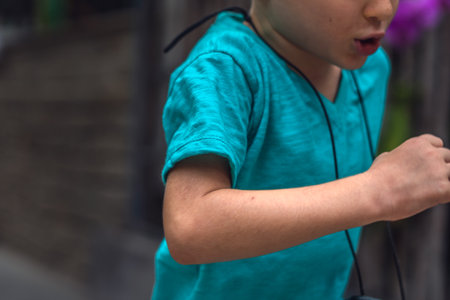 Close up side view lifestyle real leather stock photo action movement active lifestyle caucasian little boy runs hurry catch up. Concept childhood. Hand bent elbow fist shoulder. Turquoise t-shirtの写真素材