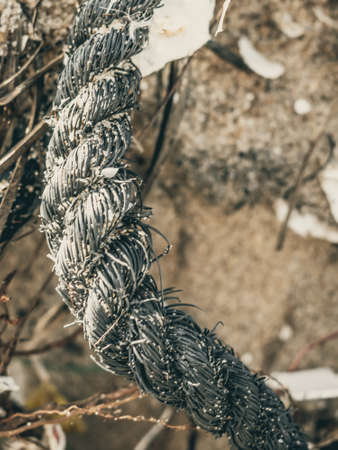 E VERTICAL Close up Macro black old fishing intertwined roughly twisted cotton rope braid detail on...