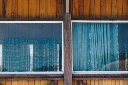 Outside view facade. Wooden yellow brown boards material, country house, panoramic window glass...