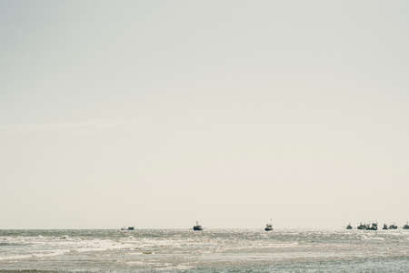 Pale blue gray tone seascape clear sky view. Real nature beauty background. boats sail skyline bay calm ripple sea. Fishing life style. trip leisure travel. Paradise tranquility serenity peace quiet.の写真素材