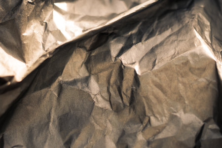 Abstract real paper surface background. Aluminum Platinum Silver foil. Wrinkled crumpled folds bend crush crease kink. Crystal, polygonal texture wave futurism 80s retro style new year. Brown toneの写真素材