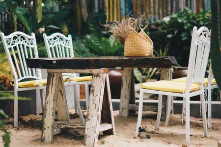 Cozy garden open air tropical style terrace old white hard wood chair table outdoor furniture. Warm mood summer nature day. Modern beauty decor interior atmosphere relax recreation dining areaの写真素材