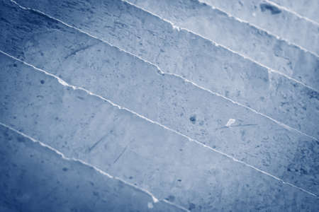 Abstract real photo background. Diagonal lines. View from above concrete stairs like ceramic stoneware tiles wall, pattern with irregular veins material texture decor design. Light blue dark vignetteの写真素材