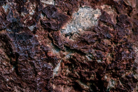 Abstract Nature beauty MACRO close up background cliff cracking rocks dramatic stones distressed face texture strong jagged sharp edges mountains. Vivid brown red dark orange. More tone in stockの写真素材