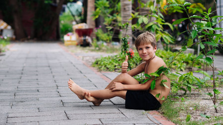 Boy blond freckles squatting sit smiling show gesture thumbs up shirtless bare chested shorts natureの写真素材