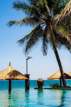 A beach scene with a palm tree and a beach hutの写真素材
