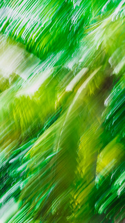 Abstract Nature Blurred dynamic motion lines defocused light bright dark green yellow tropical leaves Wallpaper screensaver design backgroundの写真素材