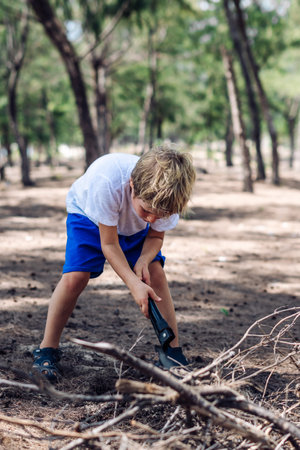 Cute boy digging soil in forest near sea beach. Family natural education skills. Travelling togetherの写真素材
